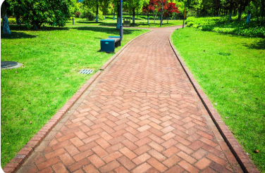 Beautiful hardscaping design featuring a curved turf pathway surrounded by green grass and clean landscape lines by a reputed landscaper in las vegas nv.